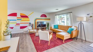 Uma sala de estar moderna com um sofá, mesa de centro e televisão.
