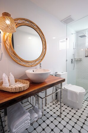 A bathroom with a large mirror, a white sink, and a glass shower enclosure. - Sand Bay Resort Semporna (Semporna)