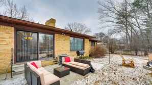 Eine Terrasse mit Gartenmöbeln, einem Grill und einem mit Schnee bedeckten Boden.