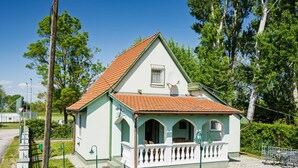 A single-story building with a red-tiled roof, a white facade, and a small balcony with a white railing. - Green House by Interhome (Balatonmariafurdo)