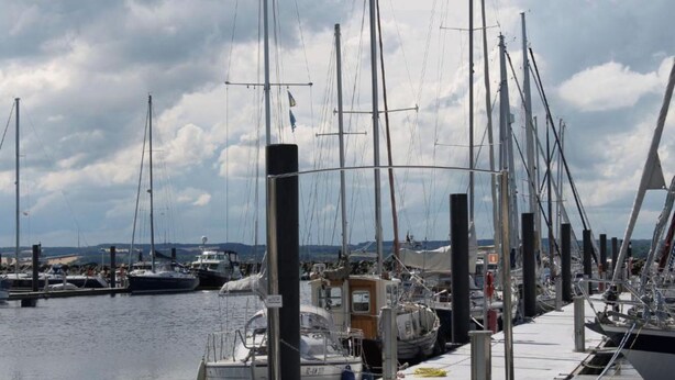 A marina with multiple sailboats docked at the pier.