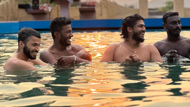 A group of people in a swimming pool with a sunset in the background. - Corniche Inn Resorts (Anaikatti)