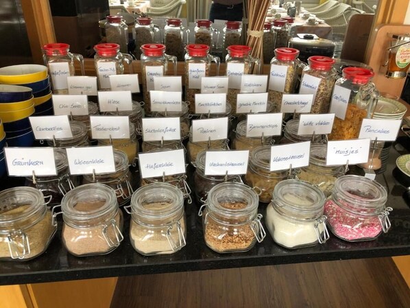 A display of various food items in glass jars with labels, arranged on a counter. - Hotel Peterchens Mondfahrt (Fulda)