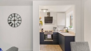 A modern kitchen with a built-in oven, a microwave, and a stainless steel range hood. - Barnet EN5 - Elegant 2Bed/1Bath Ground Floor Flat with FREE WiFi (Greater London)