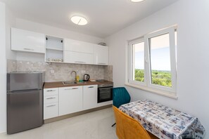 Enjoy meals in the kitchen with a refrigerator, oven, and sink, and dine at the nearby table with a view of the scenic landscape.