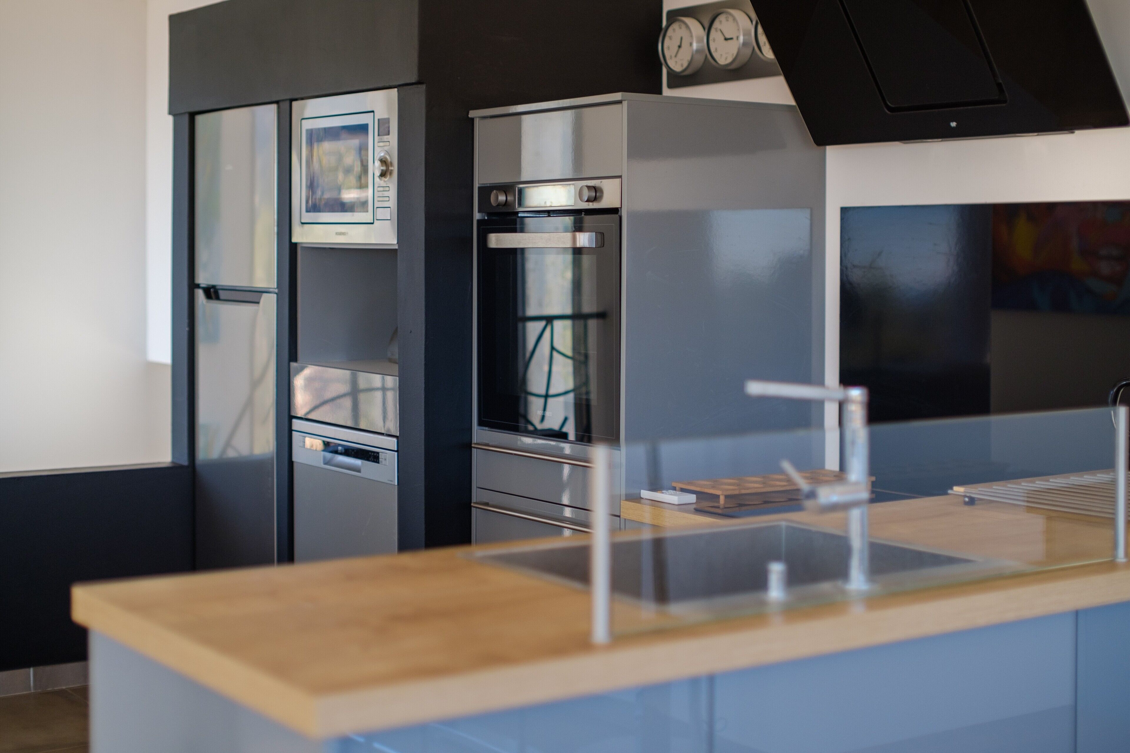 Eine moderne Küche mit Backofen, Kühlschrank und Mikrowelle.