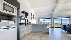A modern kitchen with a built-in microwave, coffee maker, and a view of the city.