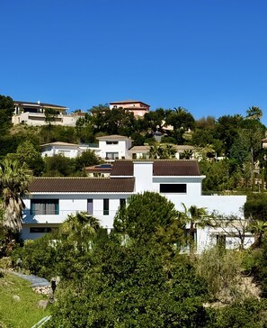Un quartier résidentiel avec des maisons construites sur une colline, entouré de verdure.