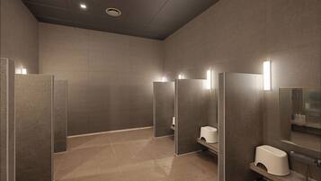 Un bagno moderno con cabine separate, un asciugamani ad aria e uno specchio.