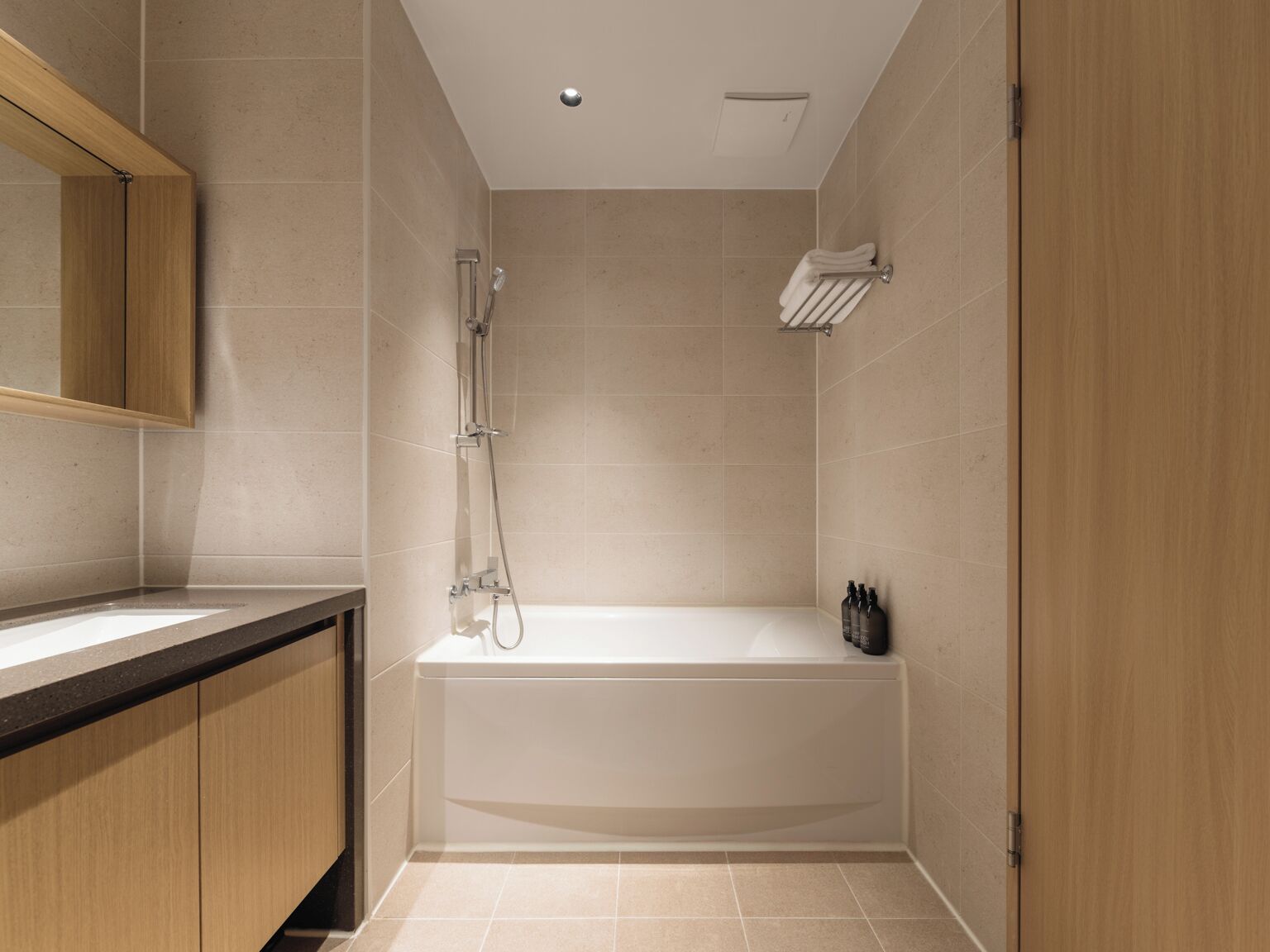 Un baño moderno con bañera, ducha y tocador con espejo.