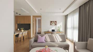 A modern living room with a sofa, a coffee table, and a dining area with wooden furniture.