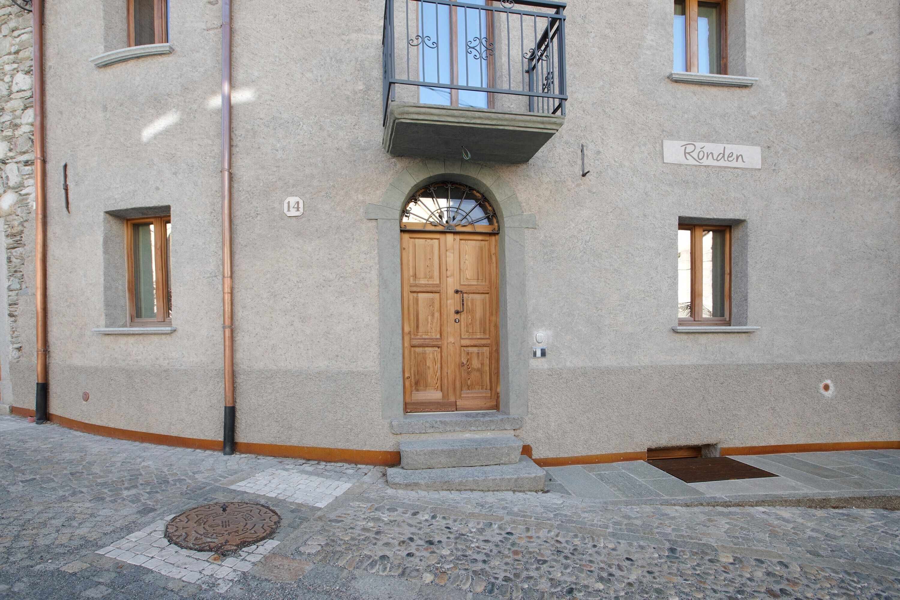A building with a wooden door, a balcony, and a sign reading 'Röden'.