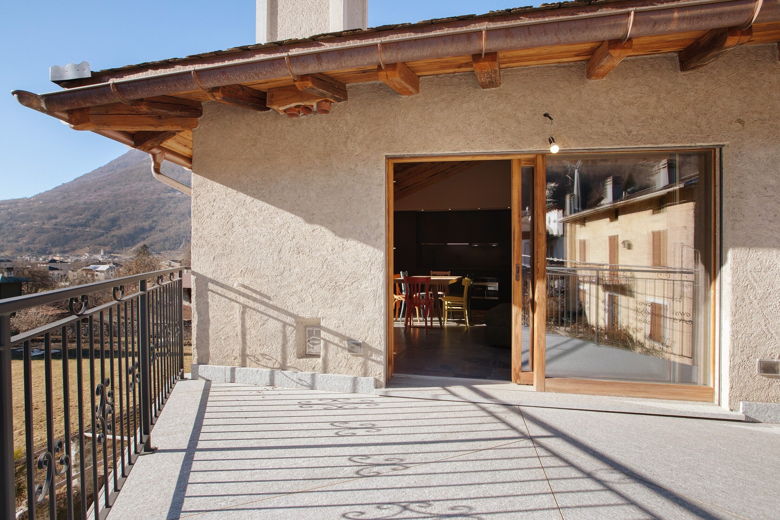 Un immeuble doté d’un balcon, d’un escalier et offrant une vue sur une montagne.