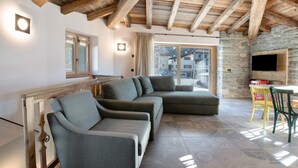 Un salon moderne avec un mur en pierre, un plafond en bois et une grande fenêtre.