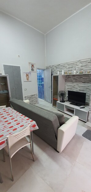 A modern living room with a sofa, TV, and a fireplace. - Apartment 'Centro Di Alcamo' with Balcony, Wi-Fi and Air Conditioning (Alcamo)