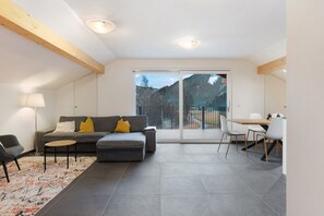 Un salon moderne avec un canapé, une table basse et un coin repas.