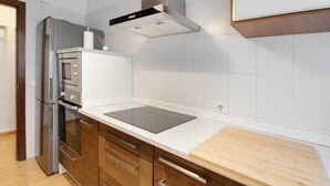 A modern kitchen with stainless steel appliances, a wooden countertop, and white tiled walls. - Apartment 'Olia' with Private Terrace, Balcony and Air Conditioning (Los Llanos)
