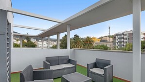 A covered outdoor seating area with wicker furniture and artificial grass. - Apartment 'Olia' with Private Terrace, Balcony and Air Conditioning (Los Llanos)