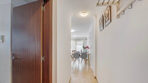 A hallway with a wooden door, a dining area with chairs and a table, and a staircase. - Apartment 'Olia' with Private Terrace, Balcony and Air Conditioning (Los Llanos)