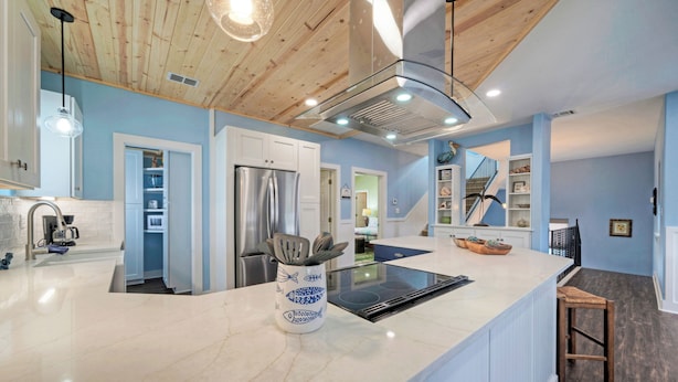 A modern kitchen with a marble countertop, stainless steel appliances, and a wooden ceiling. - Luxe Coastal Stay w/ Private Pool, Walk to Beach | Leave of Absence by AvantStay (Port Aransas)