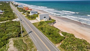 A coastal road with houses and a beach.
