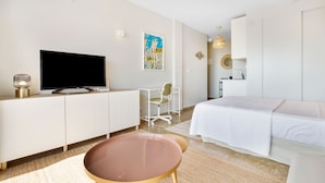 Una habitación de hotel con cama, televisor, escritorio y silla.