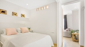A modern bedroom with a large bed, bedside tables, and wall art.