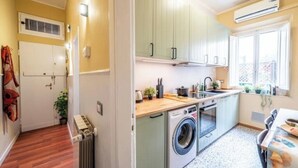 A compact kitchen with a washing machine, a sink, and a window. - Aretina Apartment Cozy (Firenze)