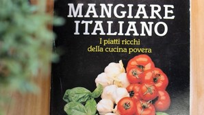 A book cover titled "Mangiare Italiano" with images of tomatoes, garlic, and basil. - Aretina Apartment Cozy (Firenze)
