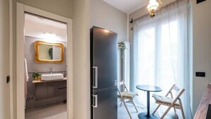 A modern bathroom with a double sink, a mirror with a gold frame, and a small plant on the counter. - Pratellino Florence Apartment (Firenze)