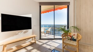 A balcony with a TV, a bench, wicker chairs, and a view of the sea. - Casa Bernardo | Sea Views (Torremolinos)