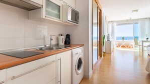 A modern kitchen with a built-in washing machine, a microwave, and a coffee maker.