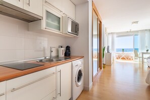 Une cuisine moderne équipée d’un lave-linge, d’un four à micro-ondes et d’une machine à café.