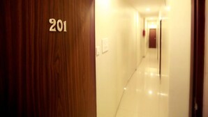 A hotel hallway with a wooden door marked '201'. - Hotel Grace Executive (Mumbai)