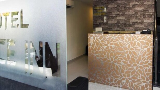 A reception area with a modern design, including a glass wall with the text "HOTEL" and a patterned wall. - Hotel Grace Executive (Mumbai)