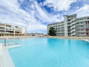 A swimming pool with a clear blue sky and buildings in the background. - Casa Ángela - Sea views (Torremolinos)