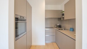 A modern kitchen with a built-in oven, a coffee maker, and a sink. - Sweett | Central Tower III (Milano)