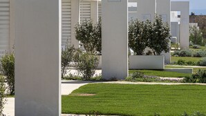 Una hilera de edificios modernos y blancos con letreros numerados que indican los números de unidad.
