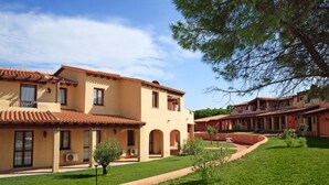 A courtyard with a building featuring a tiled roof and arched windows.