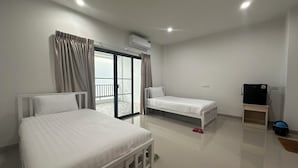 A hotel room with two single beds, a small wooden nightstand, a TV, and a sliding glass door to a balcony. - Modern House CNX (Chiang Mai)