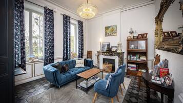 A living room with a blue sofa, a wooden coffee table, and a fireplace.