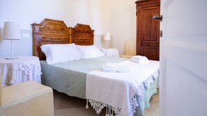 Ein ordentlich eingerichtetes Schlafzimmer mit Bett, Nachttischen und Kleiderschrank.