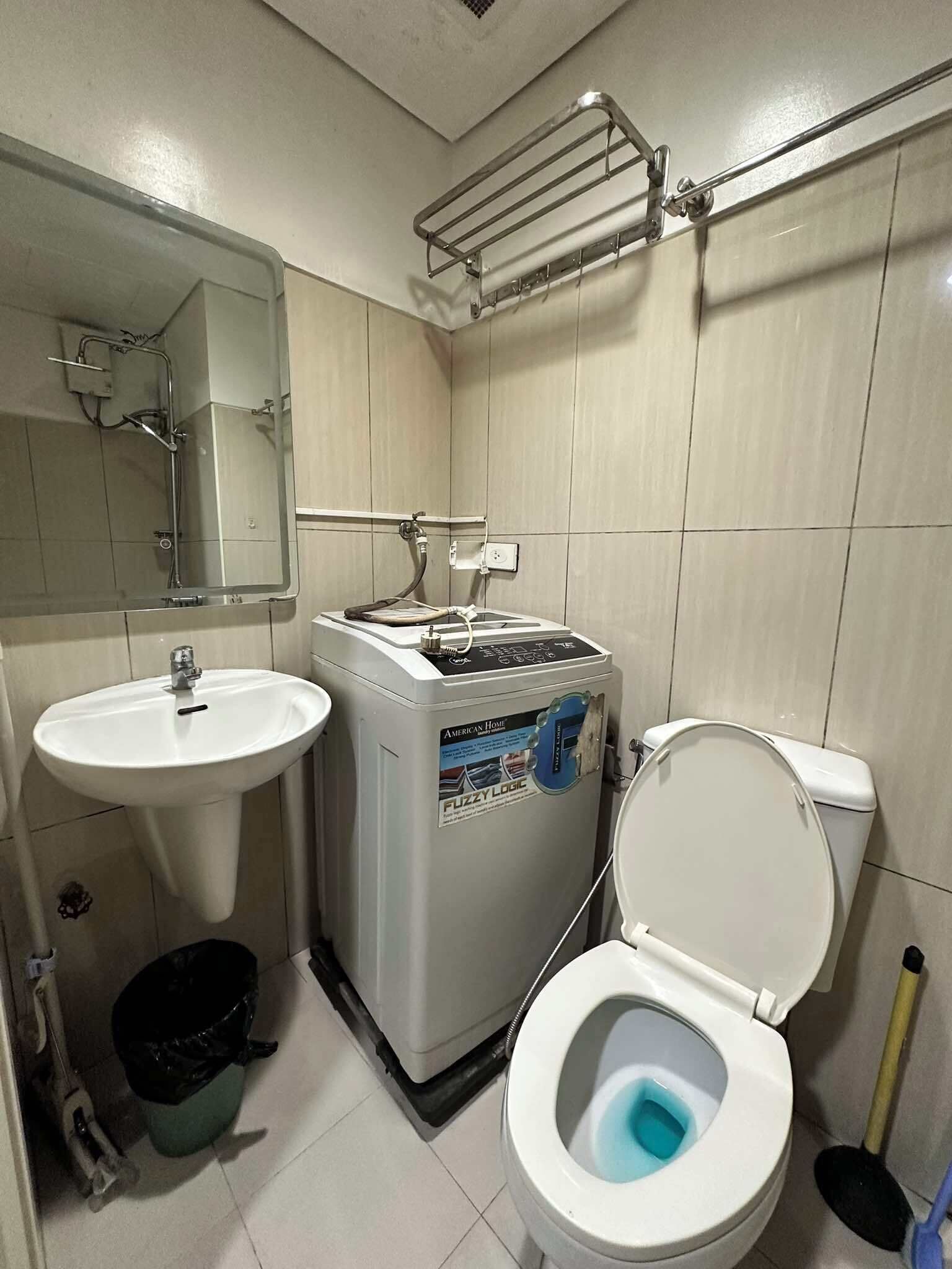 Un baño pequeño con lavamanos, inodoro y calentador de agua.