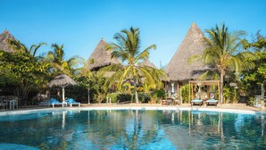 A clear blue pool with lounge chairs and thatched-roof structures, surrounded by palm trees. - Exploreans Beach Club & Villas Watamu (Malindi)