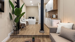 Un espacio habitable compacto con kitchenette, comedor y dormitorio.