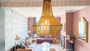 A modern living room with a large, ornate hanging light fixture, a sofa set, a glass coffee table, and a decorative mirror. - Bridge Street Rows Apartment -  a house that sleeps 8 guests  in 3 bedrooms (Chester)