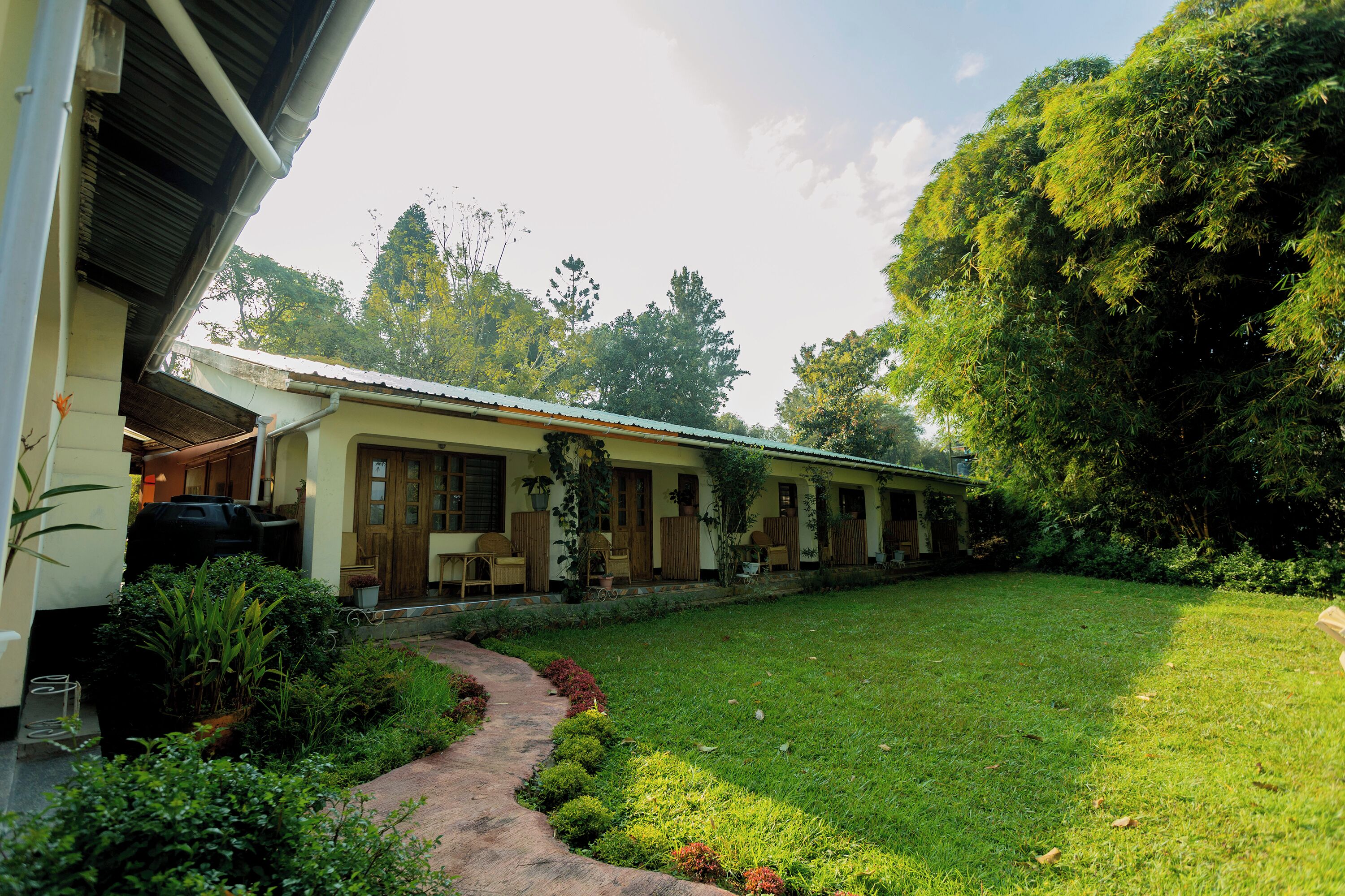 A single-story building with a covered porch, a grassy yard, and a pathway leading to the entrance.