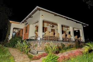 A two-story building with a covered patio area featuring outdoor seating.