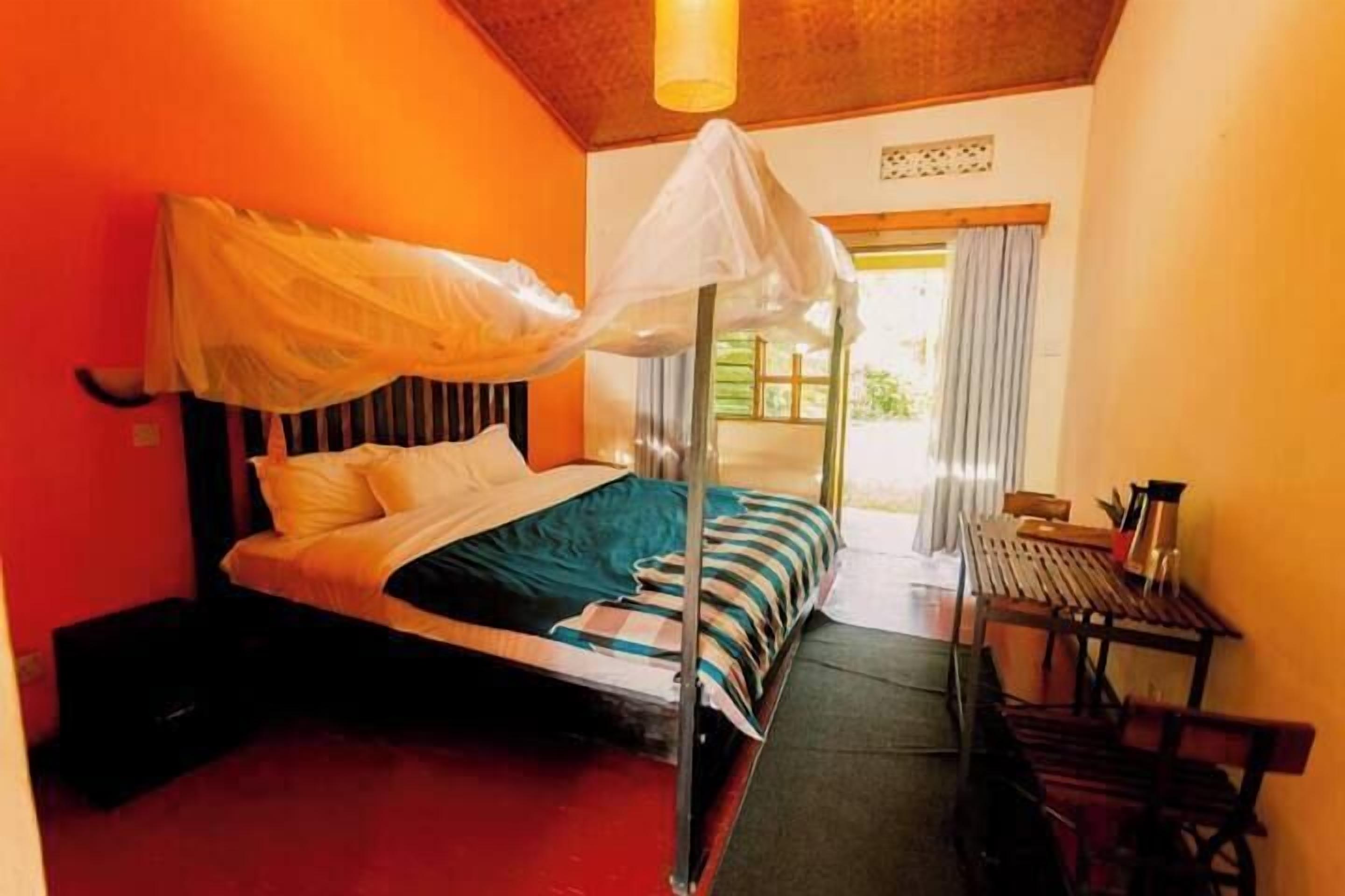 A room with a bed, a small table, and a bench.