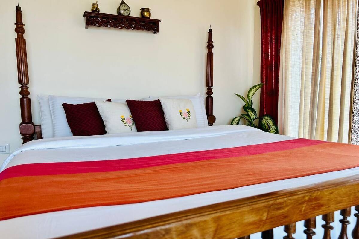 A bed with a wooden frame and a colorful bedspread.